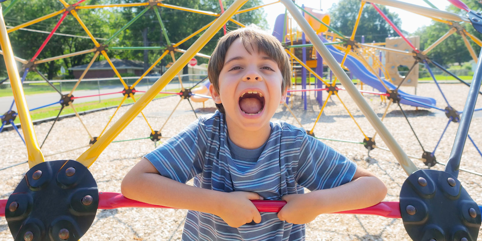 happy child playing on jungle gym at playground